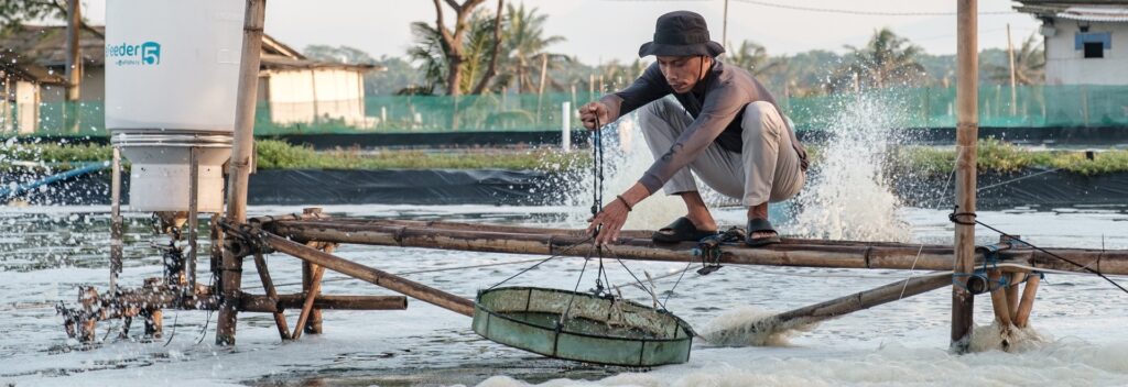 homem em estrutura de bambu manuseando instrumento de pesca