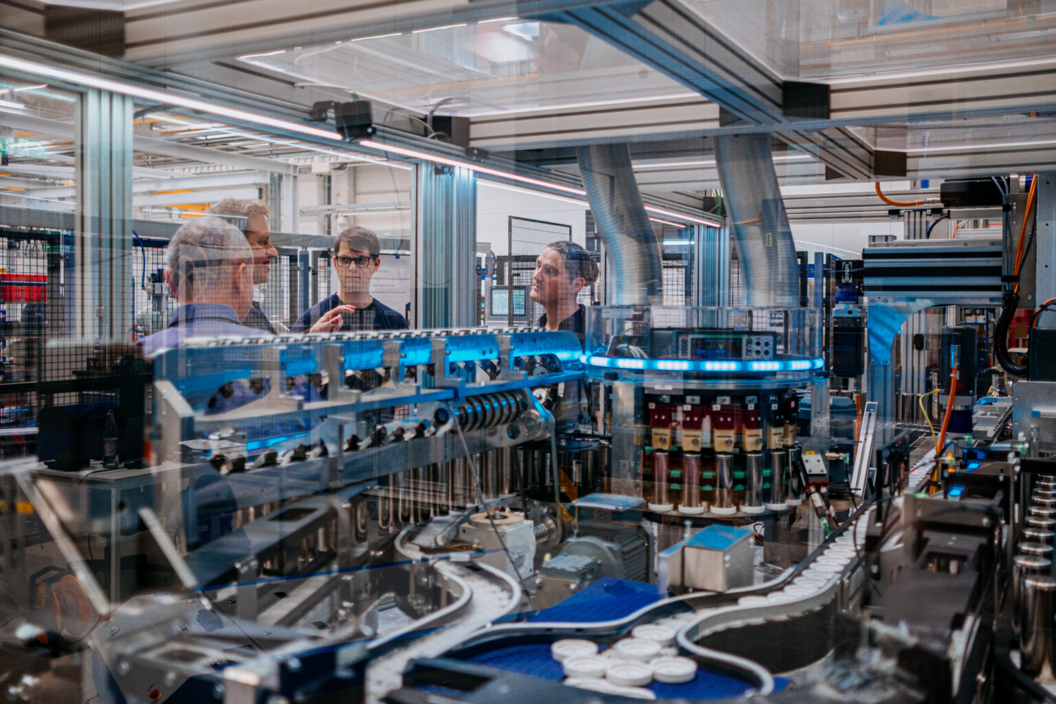 De frente para a câmera, Paul Kempt, programador da thyssenkrupp, à esquerda, e Marcus Schoenherr, engenheiro da thyssenkrupp, com a máquina de teste de células de bateria EV. Foto de Anastasia Pivovarova para Microsoft