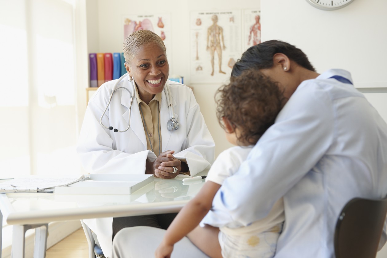 Una doctora en su consultorio con pacientes