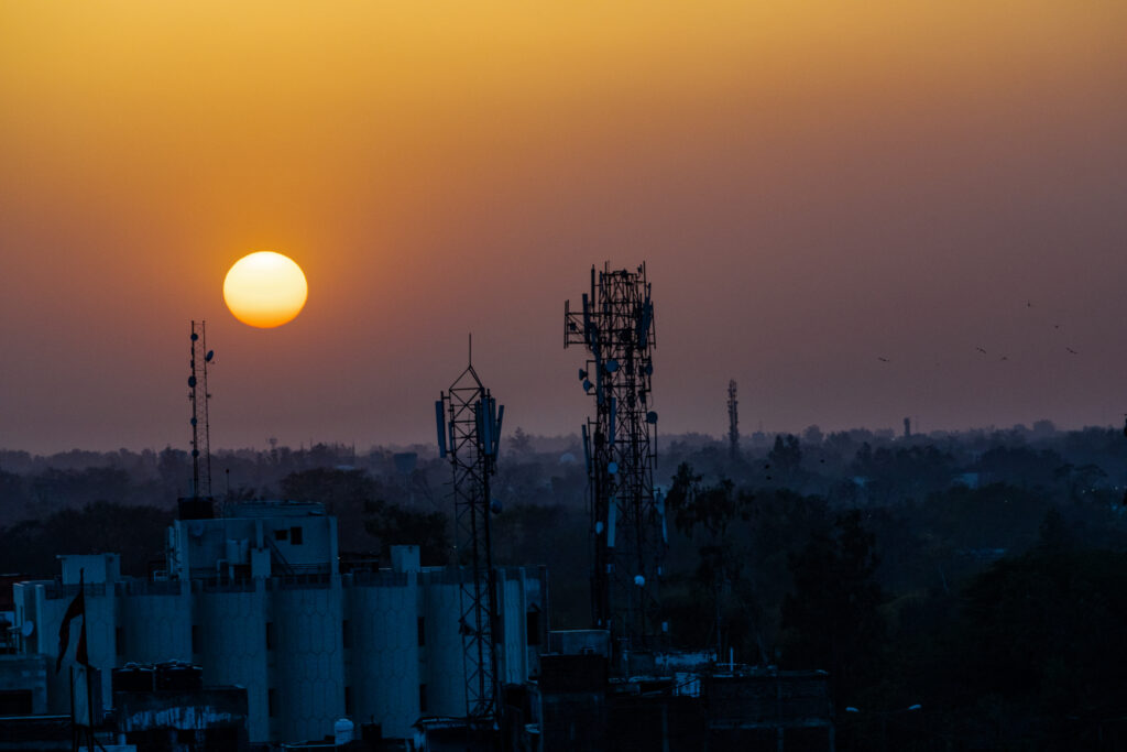 imagem mostra um pôr do sol por trás de fábricas