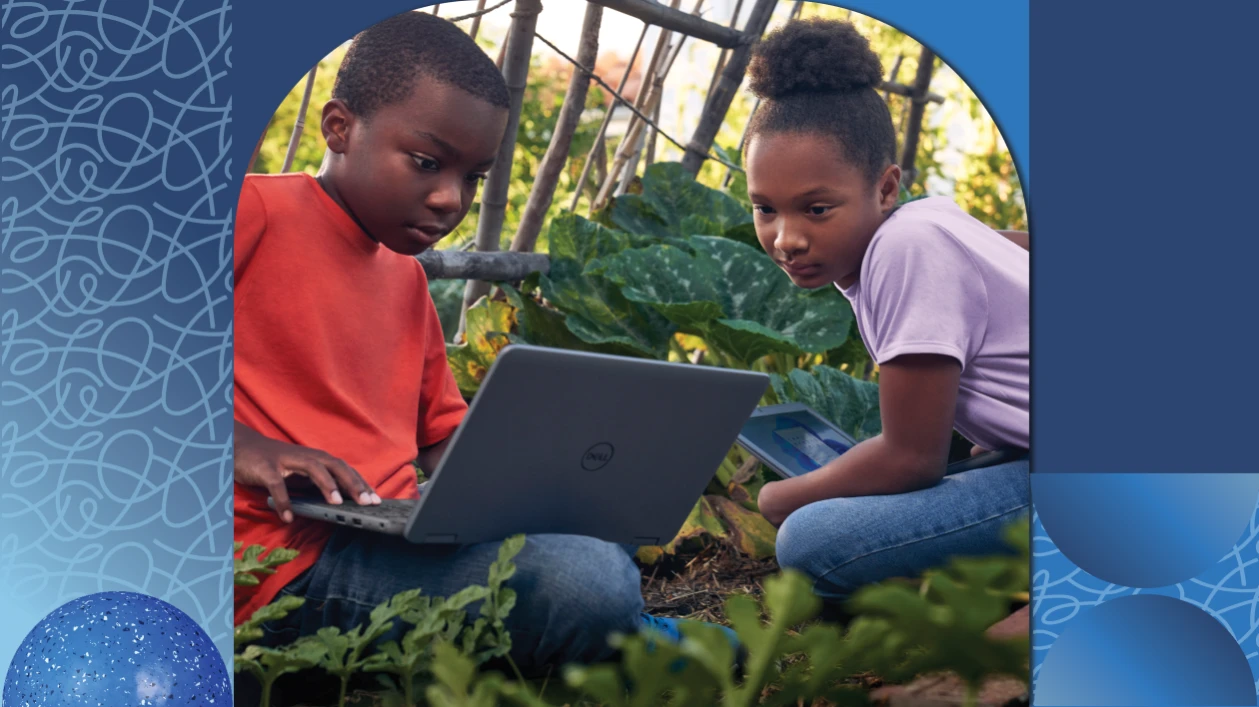Dos estudiantes sentados juntos en un jardín trabajan en un proyecto en su laptop