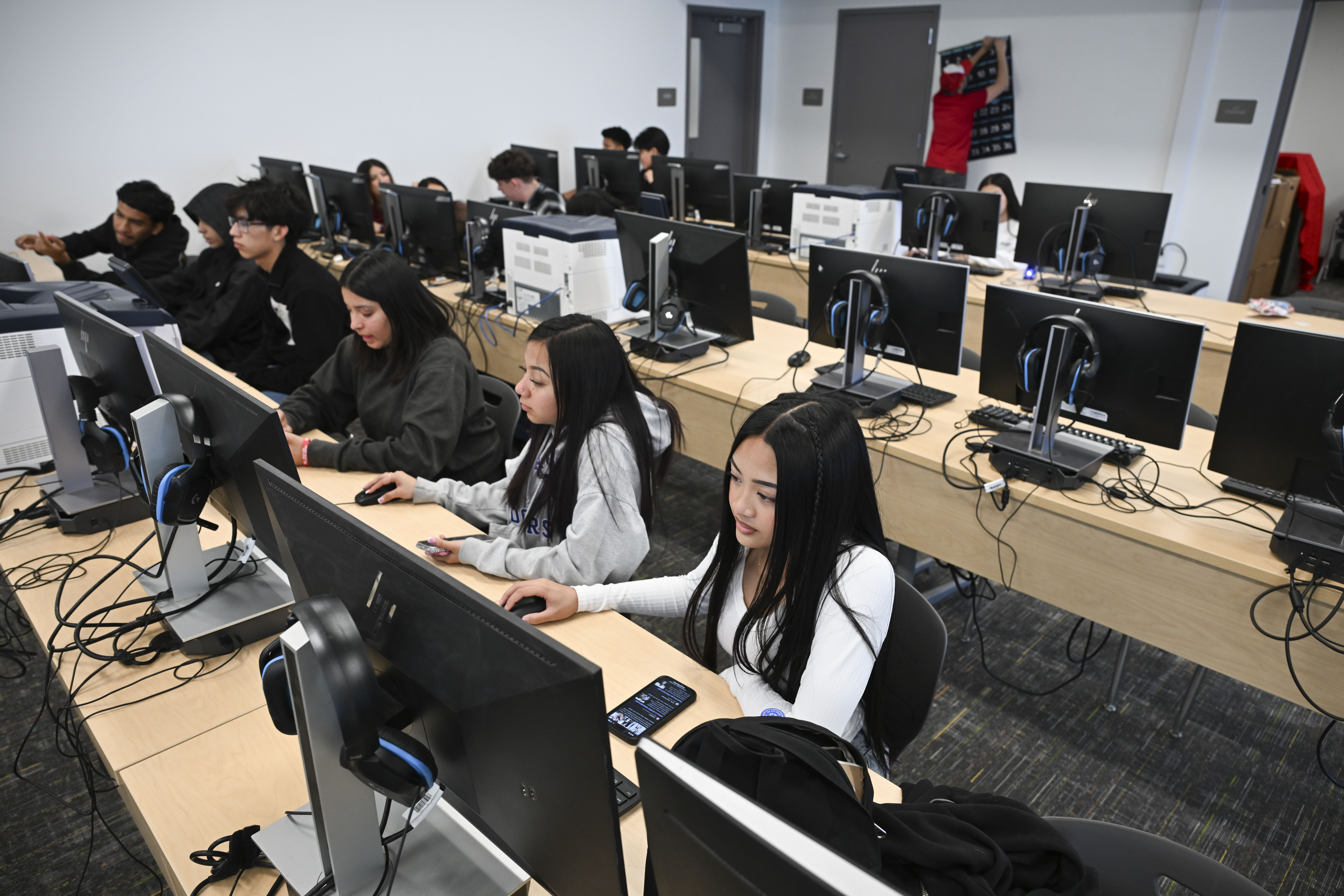 Estudiantes universitarios trabajan con computadoras en un aula