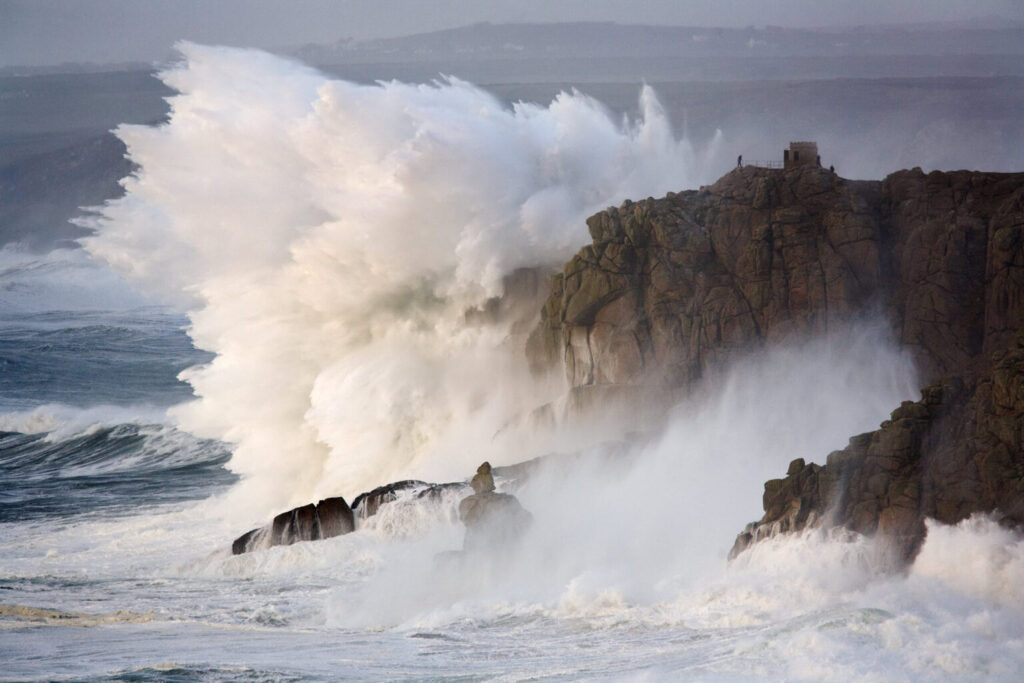 Olas de gran tamaño rompiendo contra rocas