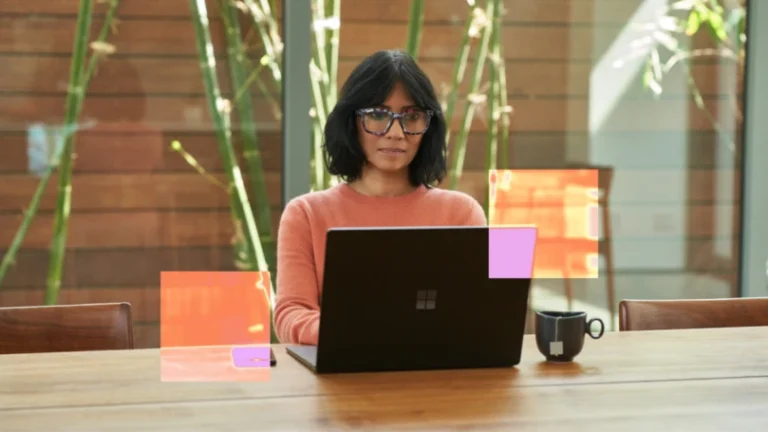 Una mujer sentada en una mesa trabaja con una laptop