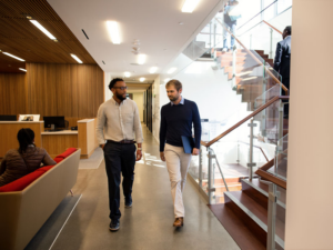 Dois homens caminhando em um corredor