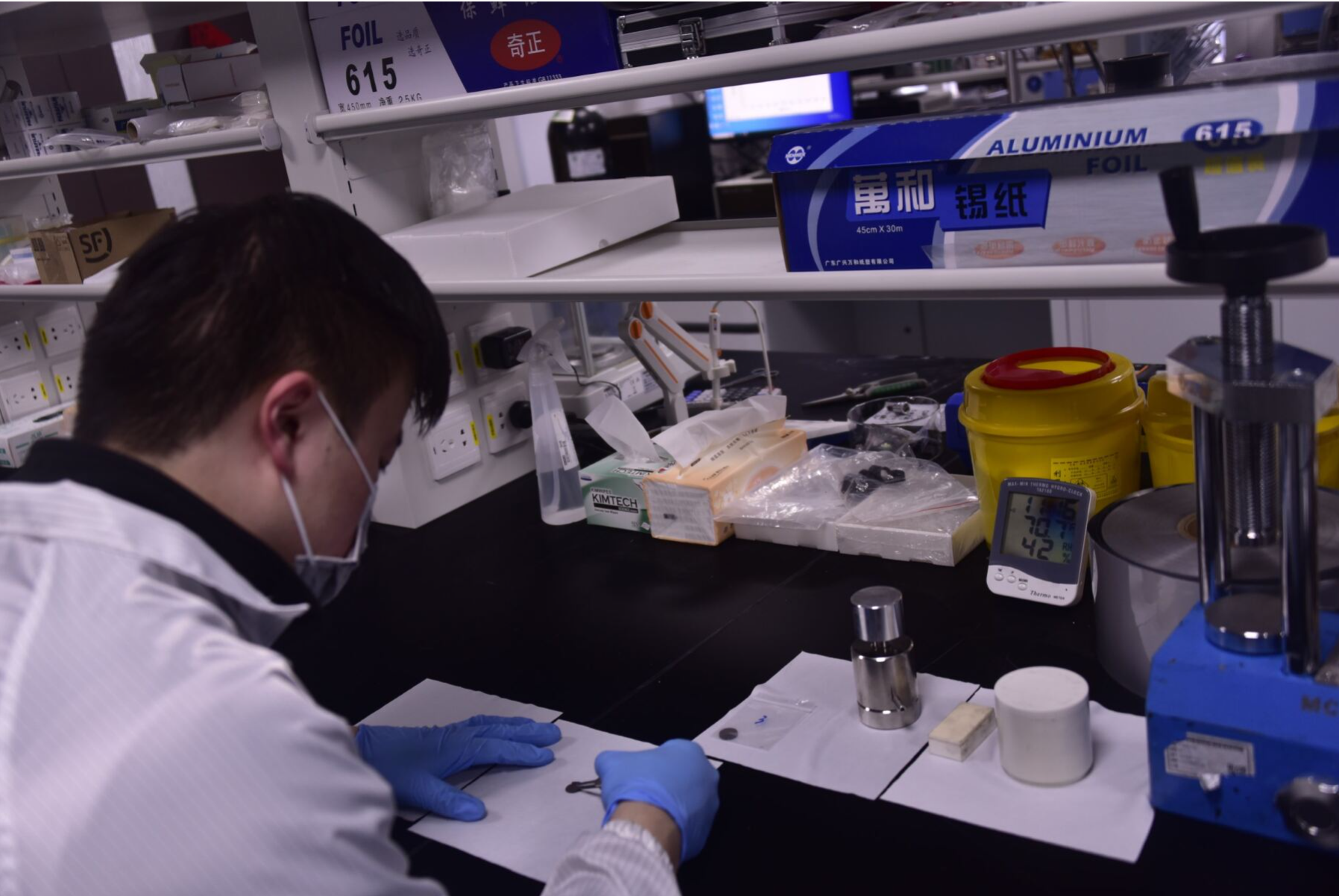 Hombre con bata, guantes y cubrebocas en un laboratorio