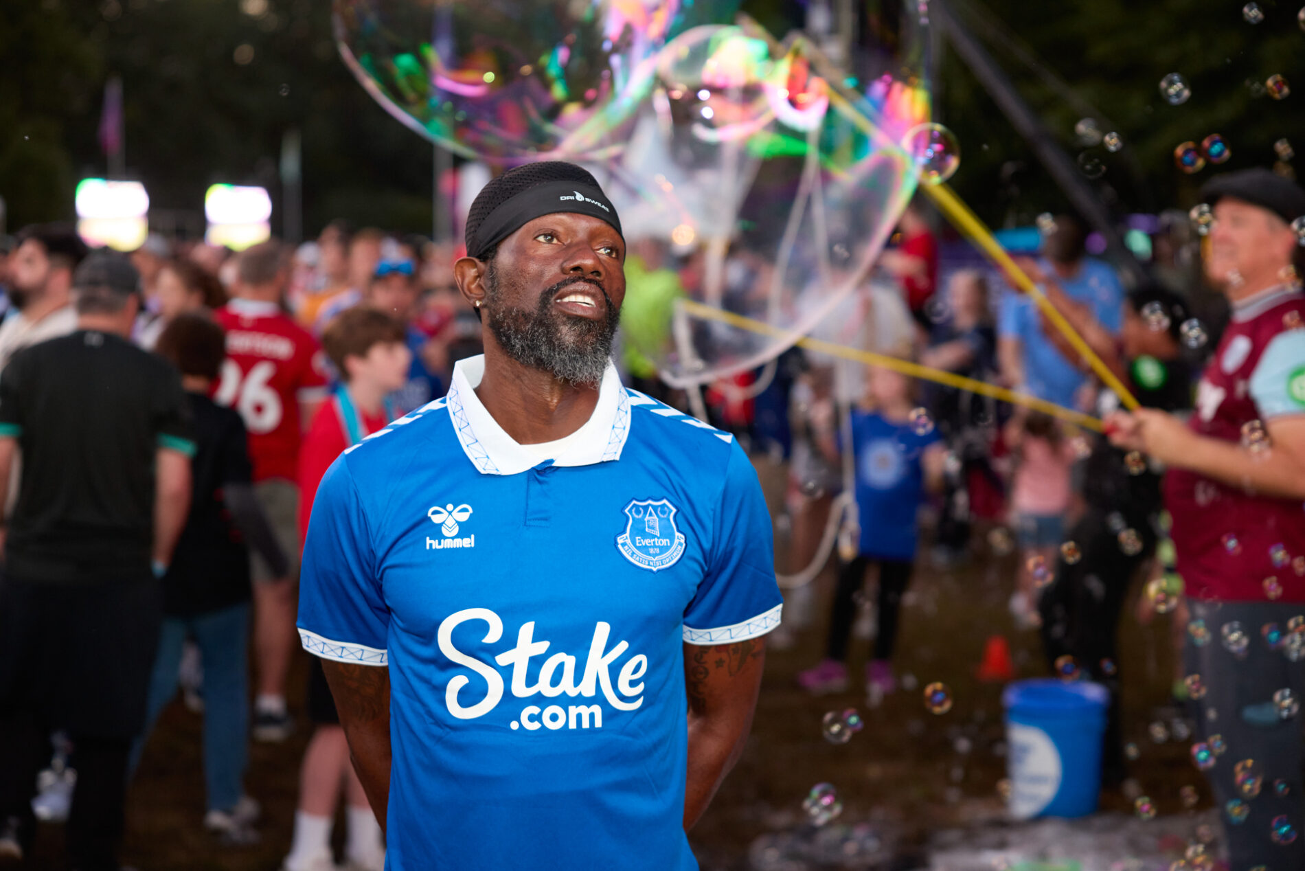 Un hombre con un jersey azul del Everton observa al frente, mientras una burbuja gigante se forma detrás de él