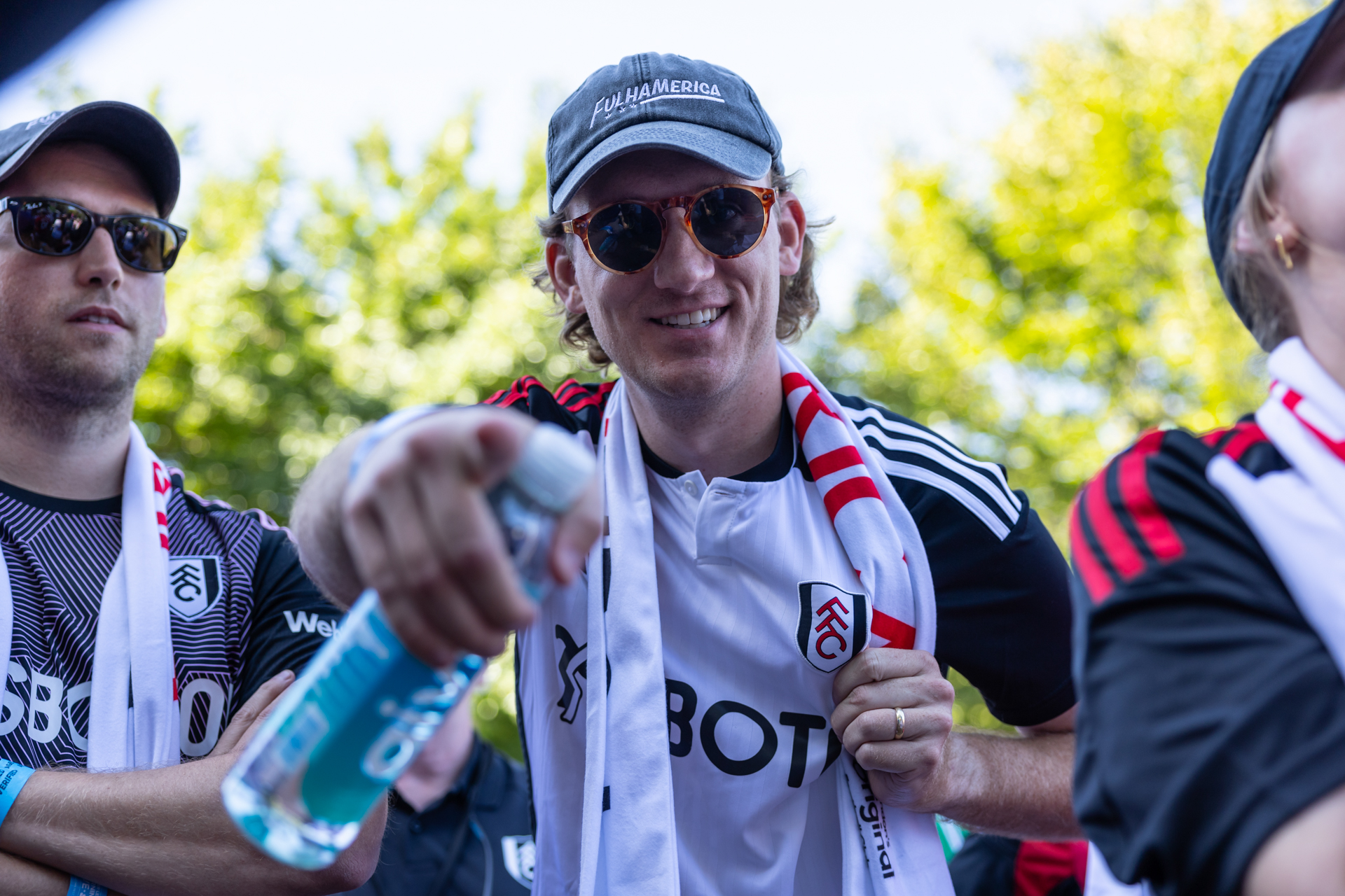 Un hombre con un jersey blanco y negro de Fulham apunta a la cámara