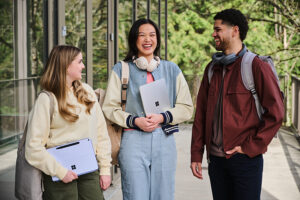 Tres estudiantes conversan fuera de un edificio